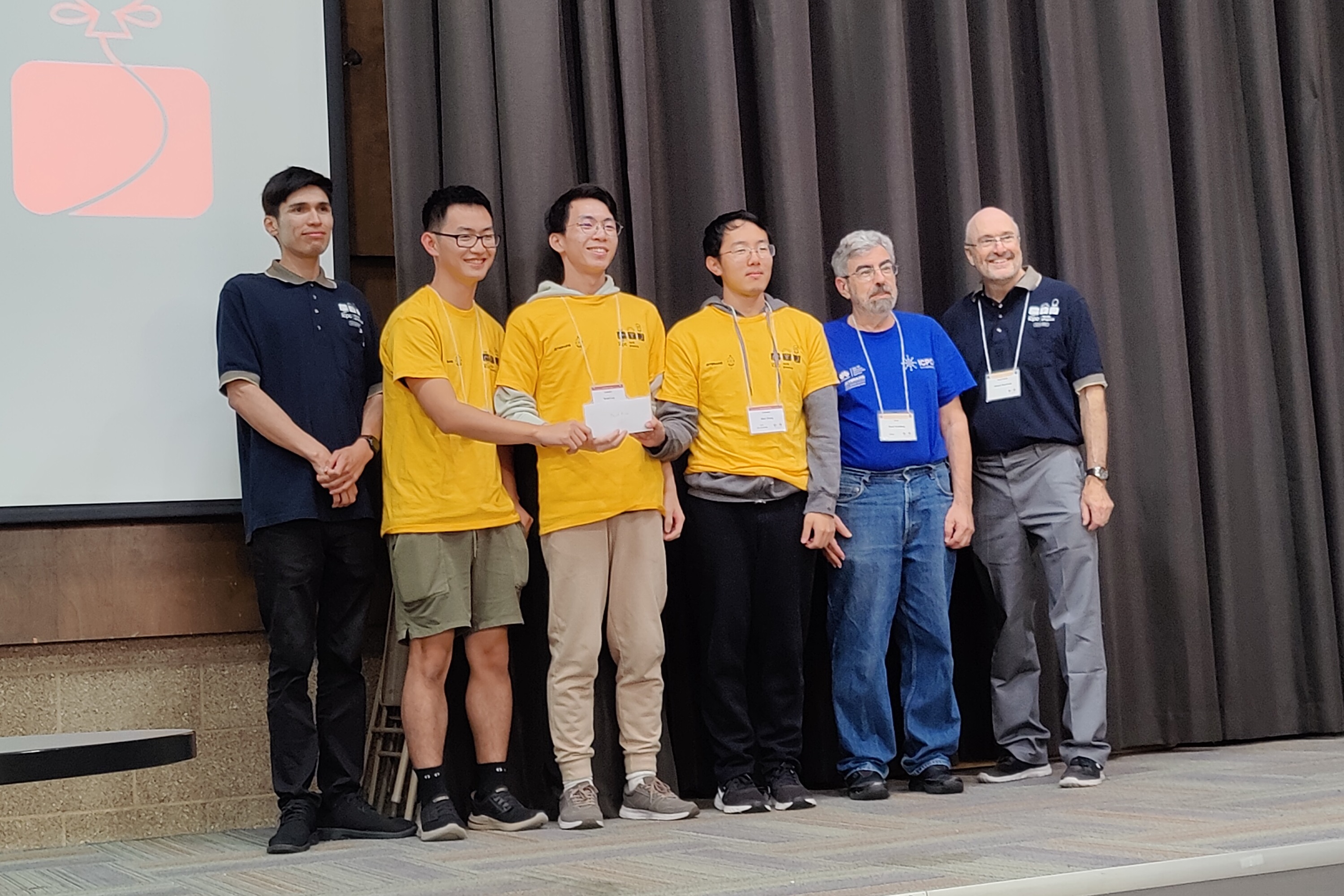 Robert, his teammates, and Professor Smallberg standing on stage for a photo op with SoCal Regional ICPC Contest coordinators.