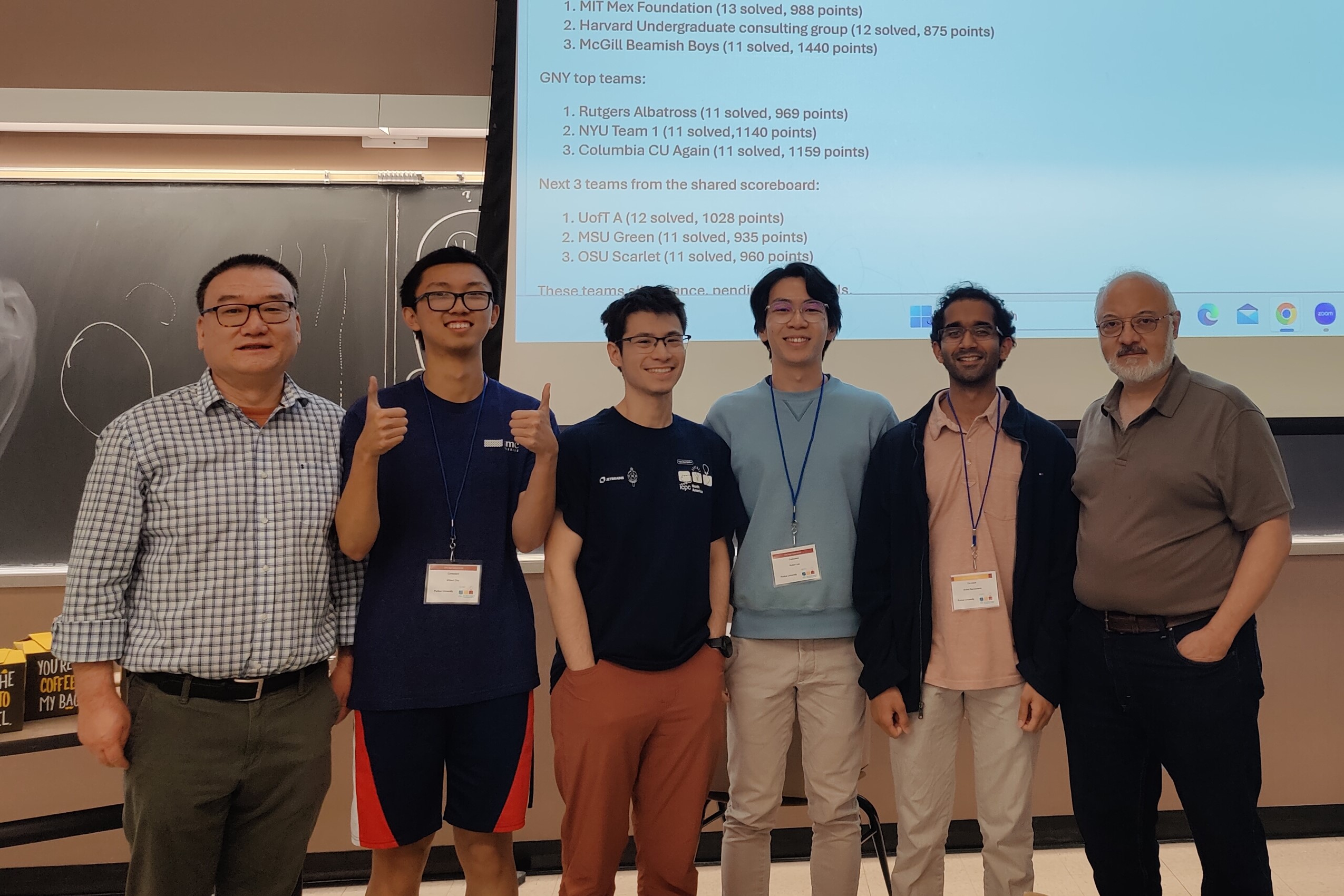 Robert and his teammates at the front of a classroom with Purdue ICPC coaches after the contest.